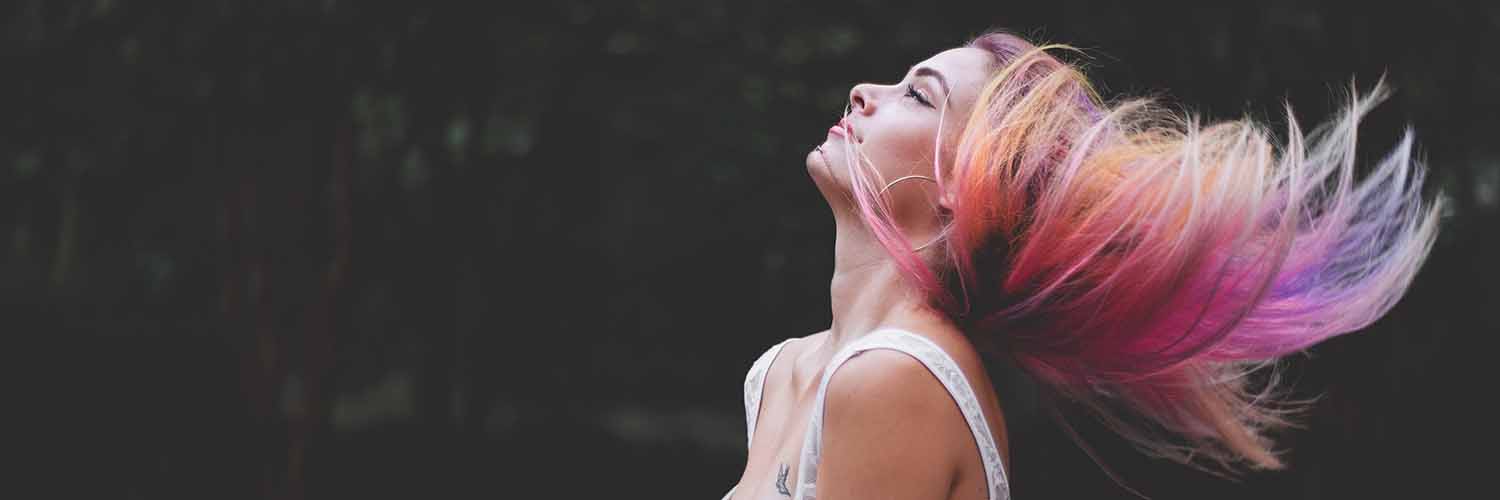 Mujer con el cabello largo en tonos rosas.